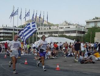 Greek runners in the Athens Classic Marathon entering the old Olympic Stadium