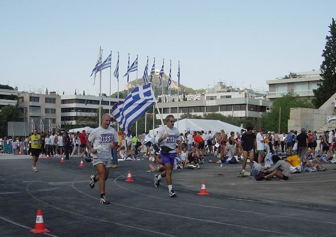Greek runners in the Athens Classic Marathon entering the old Olympic Stadium